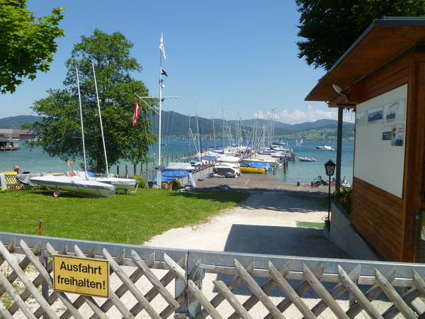 Blick von der Strasse über das Eingangstor in Richtung See mit Steg